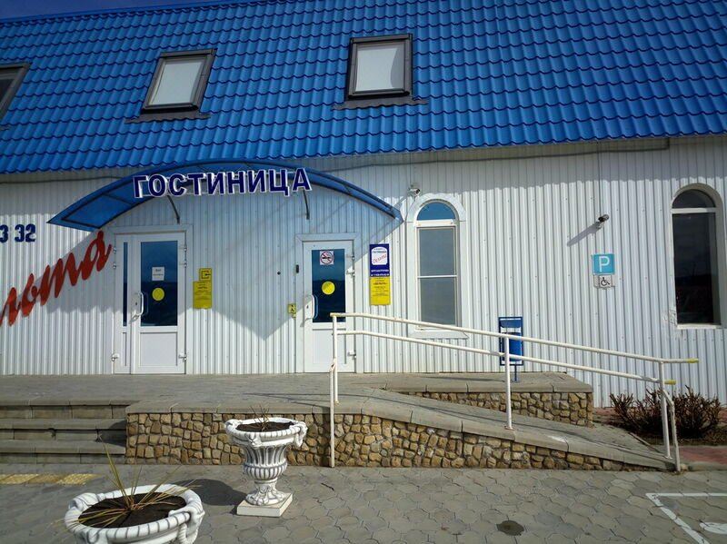 "a white building with a blue roof and a sign that reads "" ocymivla "" on the front" at Delta