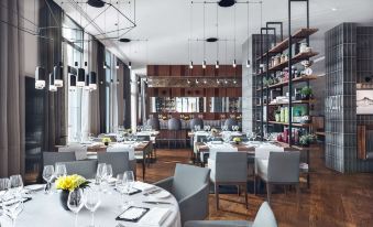 a modern restaurant with multiple dining tables and chairs , as well as a wine bar at Hilton Gdansk