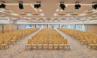 a large , empty conference room with rows of chairs and a stage set up for an event at Le Meridien Lav Split