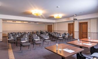 a large conference room with multiple rows of chairs arranged in a semicircle , and a podium at the front of the room at Festa Winter Palace Hotel