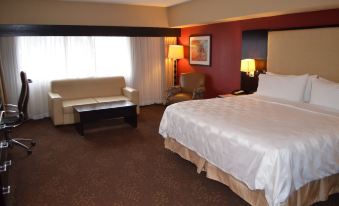 a hotel room with a king - sized bed , a couch , a dining table , and a television at Holiday Inn Clinton - Bridgewater
