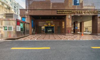 The hotel entrance features an outdoor view and parking garages on both sides at Layers The Luxurious Hotel