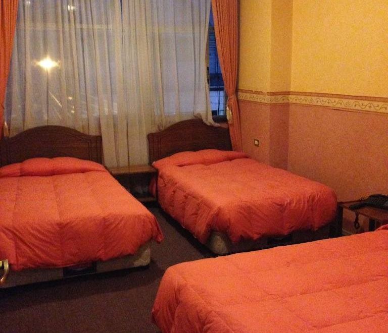 a hotel room with three beds , one on the left , one in the middle , and one on the right side of the room at Hotel Miramar