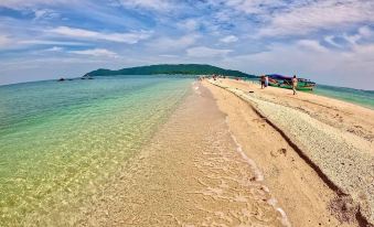 a beautiful beach with clear blue water , white sand , and people enjoying the sunny day at Hoang Trung Co to Hotel