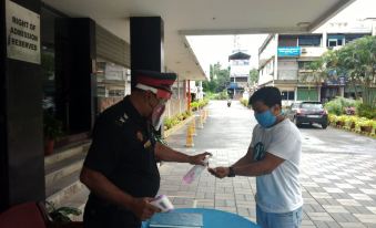 a man wearing a blue shirt is holding a card and shaking hands with a police officer at Casino Hotels Ltd