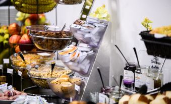 a buffet table filled with various food items , including fruits , pastries , and other desserts , arranged in multiple bowls and trays at Hotel Luna