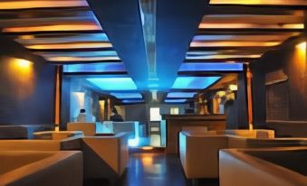 a modern restaurant with a blue ceiling and white chairs , creating a cozy atmosphere for dining at The Palms Hotel