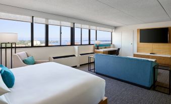 a hotel room with a large bed , a couch , and a window overlooking the ocean at Delta Hotels Muskegon Convention Center