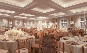 a large , elegant banquet hall filled with tables and chairs , all set for a formal event at Four Seasons Hotel Hampshire