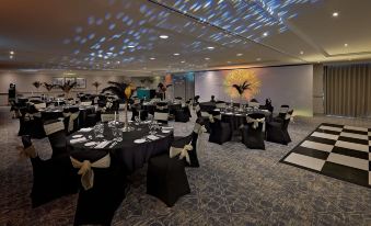 a banquet hall with several tables set up for a formal event , possibly a wedding reception at Hilton Cobham