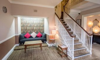 a living room with a couch , coffee table , and staircase leading to the second floor at The Knaresborough Inn - the Inn Collection Group
