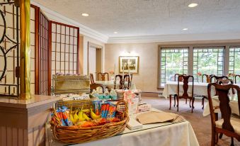 a dining room with a table set for breakfast , complete with a variety of food items and utensils at The Clarkson Inn