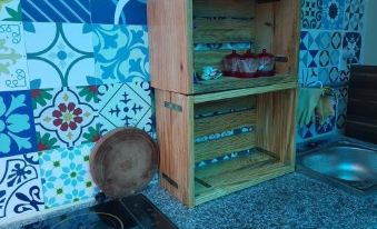 a wooden shelf with two shelves , one filled with items and the other containing red cups at Sen Villa Boutique
