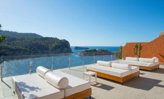 a rooftop patio overlooking a body of water , with several lounge chairs arranged in a row at Ole Galeon Ibiza