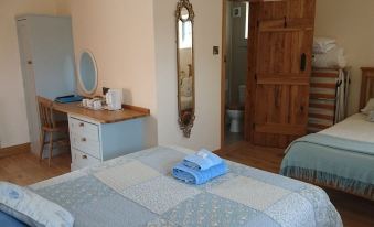 a room with two beds , one on the left side and another on the right side at Church Farm Accomodation