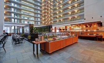a large , modern building with a high ceiling and an orange food display in the middle at Embassy Suites by Hilton Chicago Downtown Magnificent Mile
