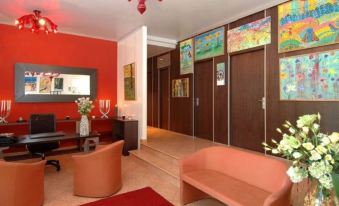 a well - decorated living room with red walls , a couch , a chair , and a dining table at Art Hotel