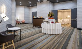 a large , well - lit conference room with a reception area and a dining table set for a meal at Holiday Inn Long Island - Islip Arpt East