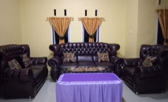 a living room with two couches , one on the left and the other on the right , and a dining table in the middle at Sinar Harapan