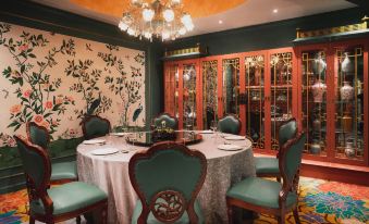 A dining room is equipped with a large table and chairs, arranged for a seating capacity of 10 people at Lan Kwai Fong Hotel @ Kau U Fong