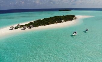 an aerial view of a tropical island with clear blue water and several boats in the distance at Beach Cottage