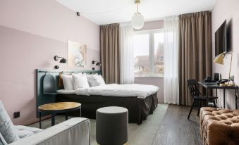 a modern hotel room with a large bed , pink walls , and various pieces of furniture at Best Western Plus Hus 57