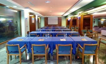 a conference room set up for a meeting , with several chairs arranged in rows and a projector on the wall at Vik Gran Hotel Costa del Sol