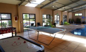 a large room with multiple tables , including a ping pong table , a pool table , and a foosball table at Streaky Bay Hotel Motel