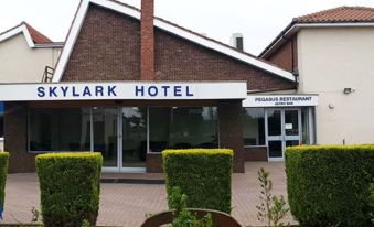 "a brick building with a sign that reads "" skylark hotel "" prominently displayed on the front of the building" at Skylark Hotel