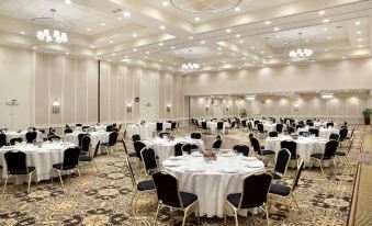 a large , well - lit banquet hall with numerous tables and chairs set up for a formal event at Hilton Lexington/Downtown
