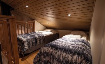 a room with two beds , one on top of the other , and a wooden ceiling at Ranua Resort Holiday Villas