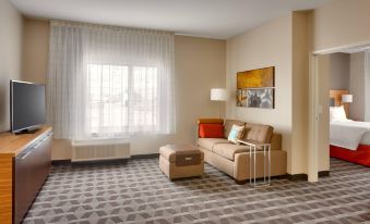 a cozy living room with a couch , a chair , and a tv . also a dining table in the room at TownePlace Suites Clovis