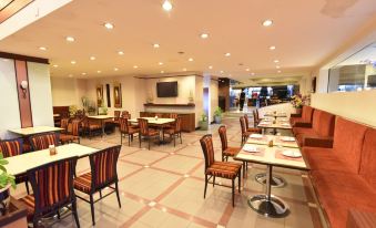 a large dining room with tables and chairs arranged for a group of people to enjoy a meal together at Asian Hotel