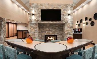 a fireplace with a television above it and two orange balls on the floor in front of it at Homewood Suites by Hilton Columbus - Hilliard