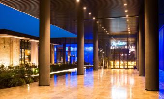 a large , modern hotel lobby with high ceilings , stone flooring , and high ceilings lit by lights at Radisson Hotel, Dakar Diamniadio