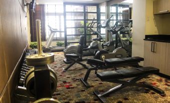 a well - equipped gym with various exercise equipment , including treadmills and weight machines , in a spacious room at Brentwood Suites