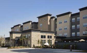 a modern hotel building with multiple floors , surrounded by palm trees and a parking lot at Residence Inn Philadelphia Willow Grove
