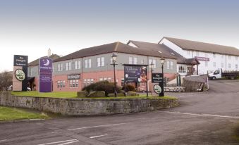 a large brick building with a sign on the side , located in a city setting at Premier Inn Whitehaven