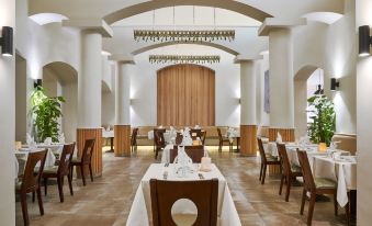 a large dining room with multiple tables and chairs arranged for a group of people at Three Corners Rihana Resort El Gouna