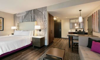 a hotel room with a large bed , a desk , and a mirror in the bathroom area at Embassy Suites by Hilton Berkeley Heights