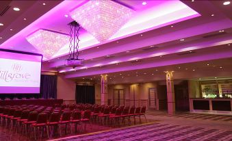 a large , well - lit room with rows of chairs and chandeliers hanging from the ceiling , creating an elegant atmosphere at Hillgrove Hotel, Leisure & Spa