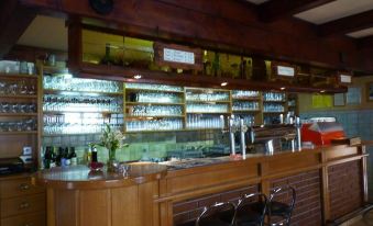a well - stocked bar with wooden shelves and a variety of wine glasses and bottles on display at Gasthof Zur Post