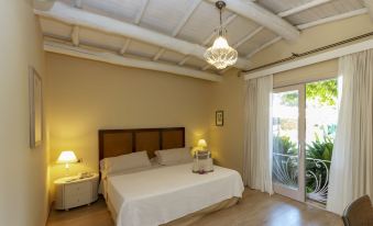 a spacious bedroom with a large bed , a closet , and a door leading to a patio at Hotel Simius Playa