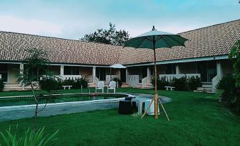 a beautiful outdoor setting with a swimming pool surrounded by lush greenery and umbrellas , creating a relaxing atmosphere at Baan Kub Doi Mae Chaem