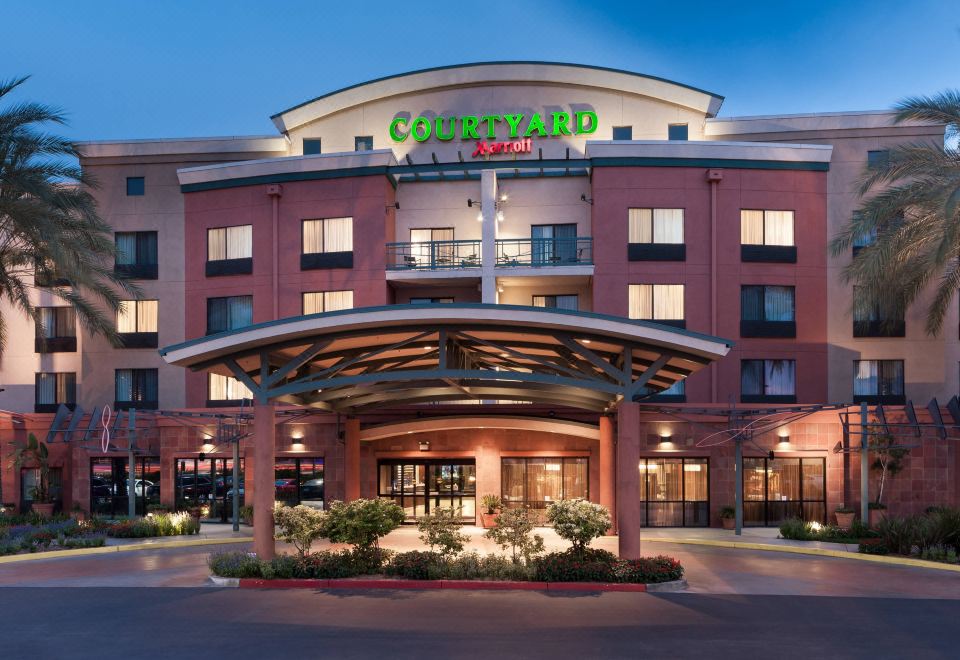 a hotel entrance with a large sign above it , welcoming guests to the courtyard by marriott hotel at Courtyard Los Angeles Burbank Airport