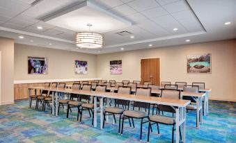 a large conference room with rows of chairs arranged in a semicircle , ready for a meeting at Home2 Suites by Hilton Fort Mill