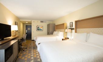a hotel room with two beds , white linens , and a checkered floor , along with some other amenities at Holiday Inn Morgantown - Reading Area