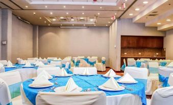 a large banquet hall with multiple tables set for a formal event , featuring blue tablecloths and white chairs at Quality Inn Monterrey la Fe