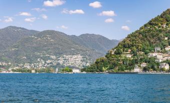 a large body of water with mountains in the background , creating a serene and picturesque scene at Ibis Como