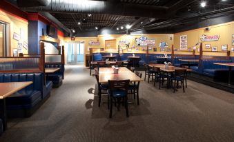 a restaurant with blue tables and chairs , wooden booths , and yellow walls is shown at Holiday Inn Rock Springs